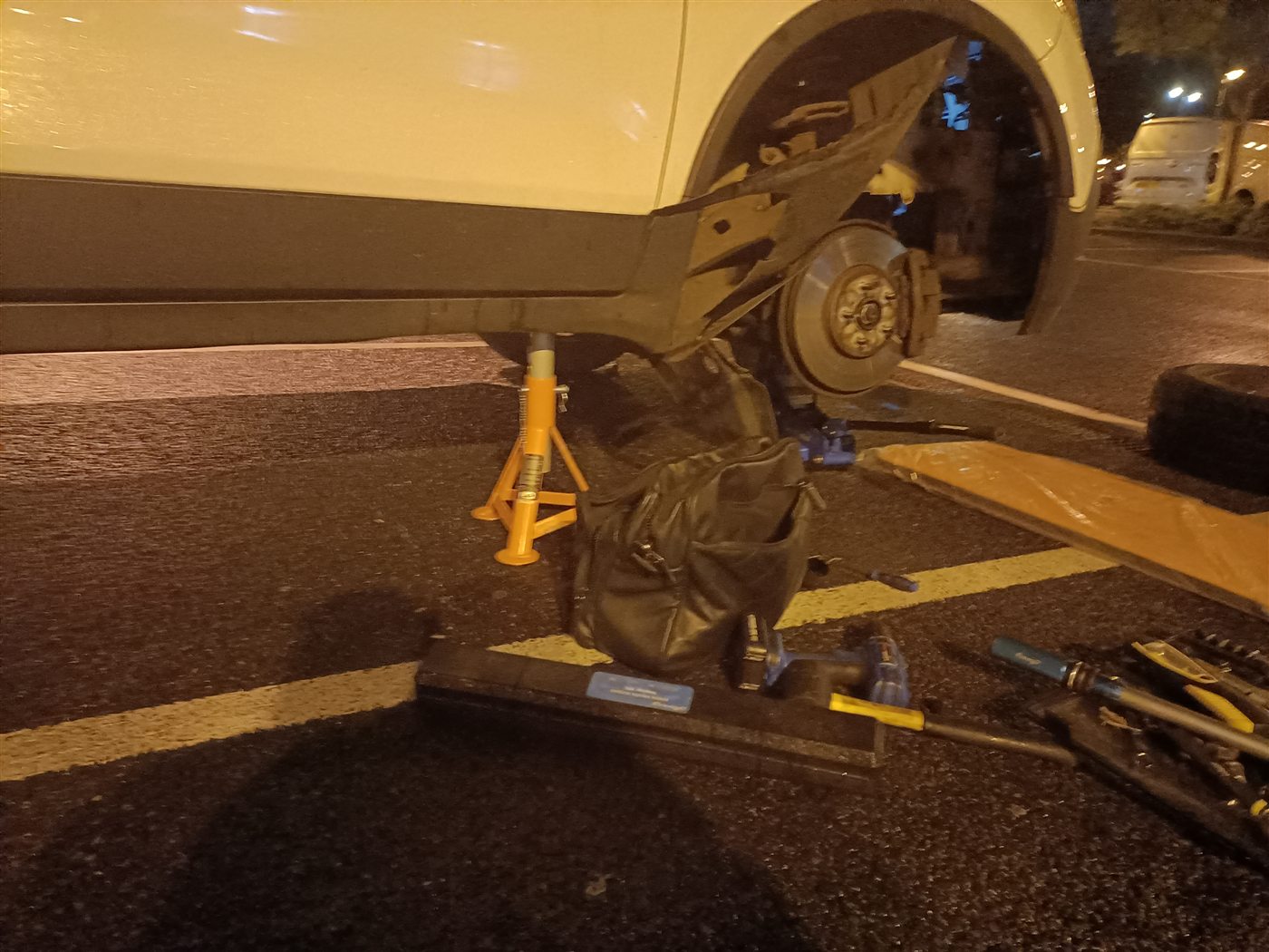 Roadside wheel and suspension work at night